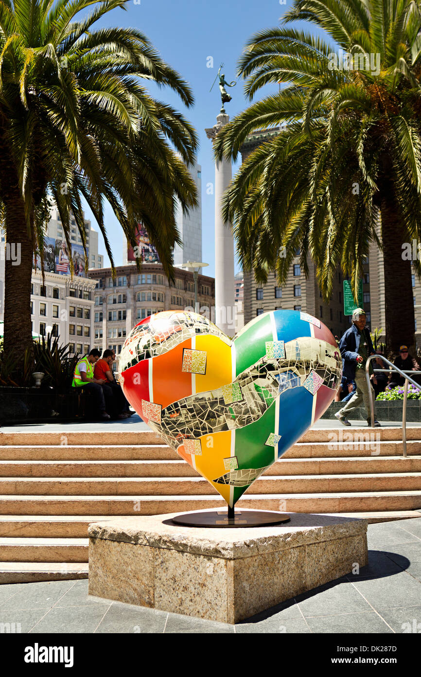 Rainbow heart-shape sculpture in sunny town square with palm trees, San Francisco, California, United States Stock Photo