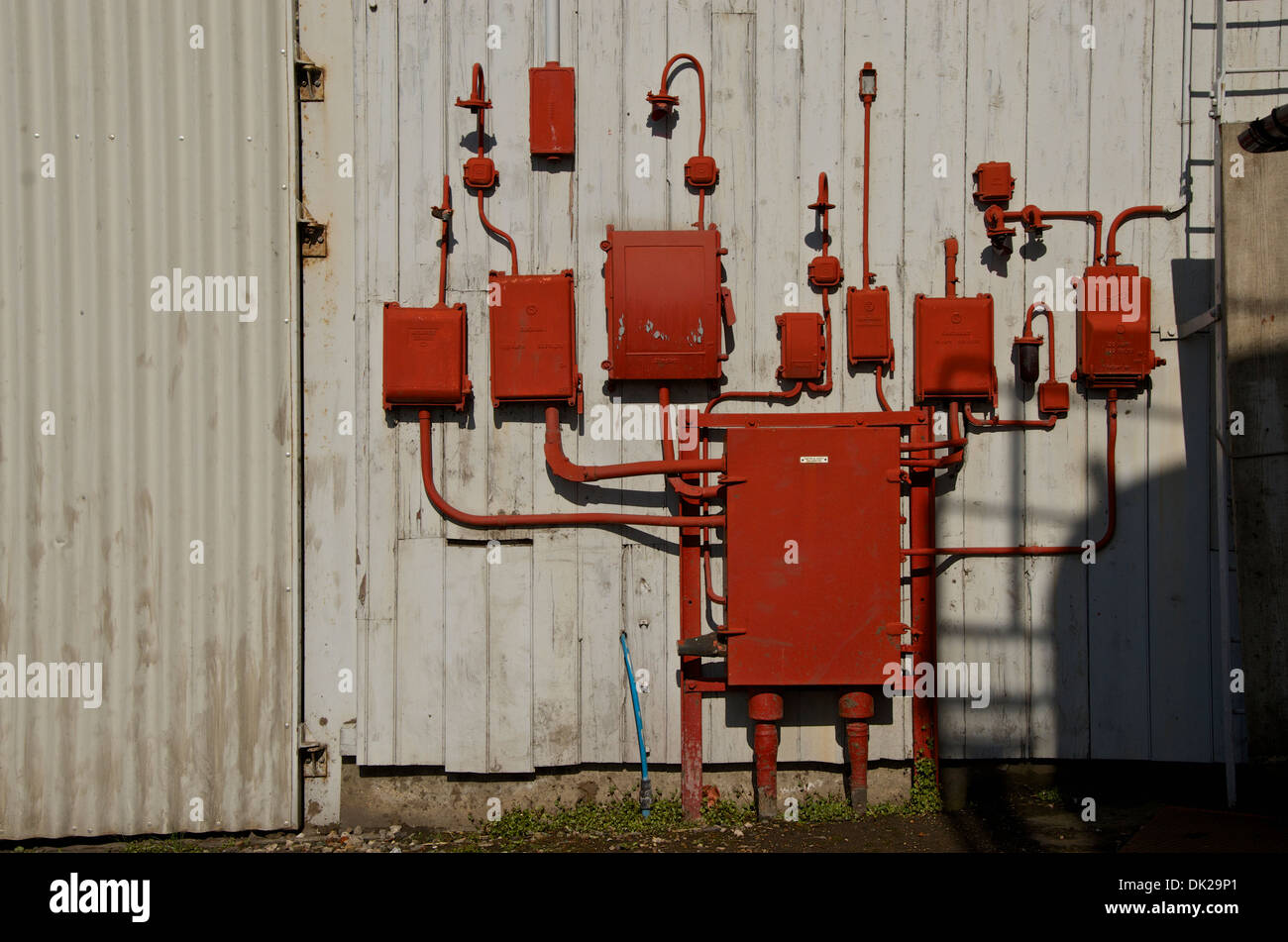 Old red electric junction boxes and lamps labeled electrical supply disconnected. Stock Photo