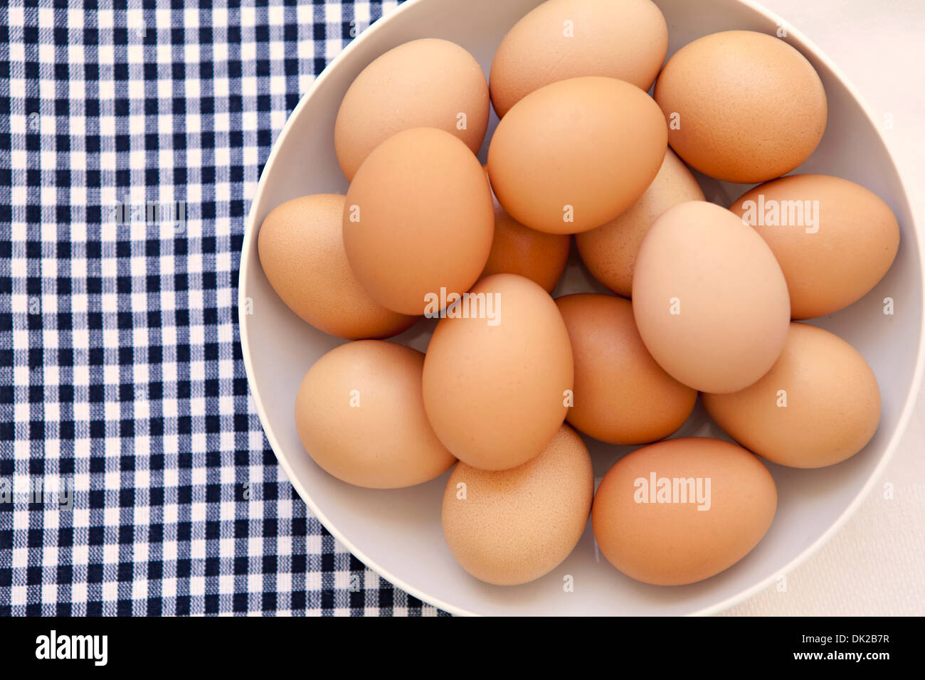 View from directly above of organic brown eggs on checkered gingham napkin from directly above Stock Photo