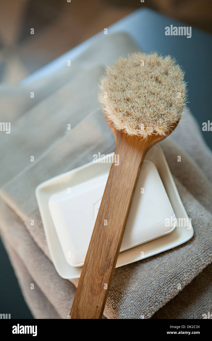 High angle view of scrub brush on top of soap and stack of towels in spa Stock Photo