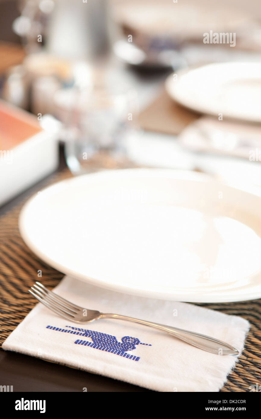 Close up of place settings and stitched Guatemalan napkin on table Stock Photo