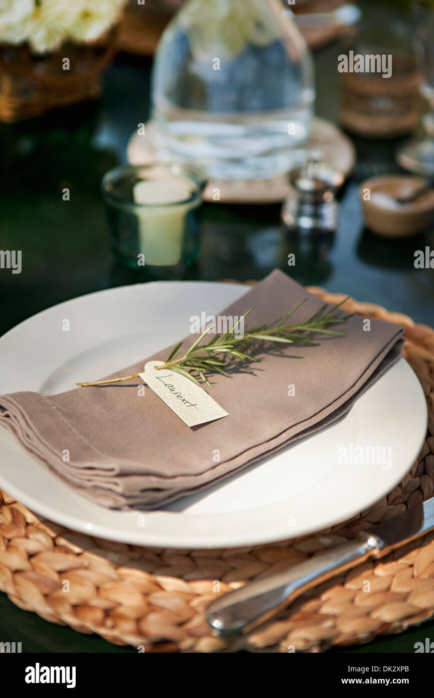 Close up of place setting on patio table with herb placecard Stock Photo