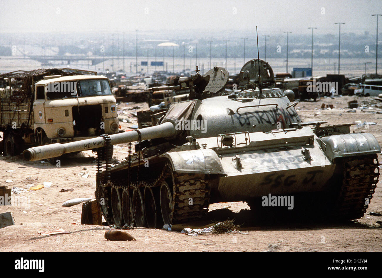 A destroyed Iraqi T-55 main battle tank, painted with graffiti by Coalition troops, lies amidst other destroyed vehicles along Kuwait Highway 8, the route fleeing Iraqi forces took as they retreated from Kuwait during Operation Desert Storm April 18, 1991 in Kuwait. The road is known as the 'highway of death' because of the number of vehicles destroyed by allied forces. Stock Photo