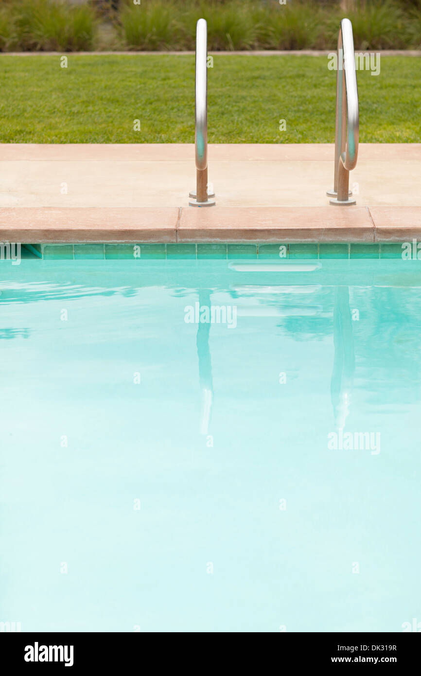 Handrails at calm hotel swimming pool Stock Photo