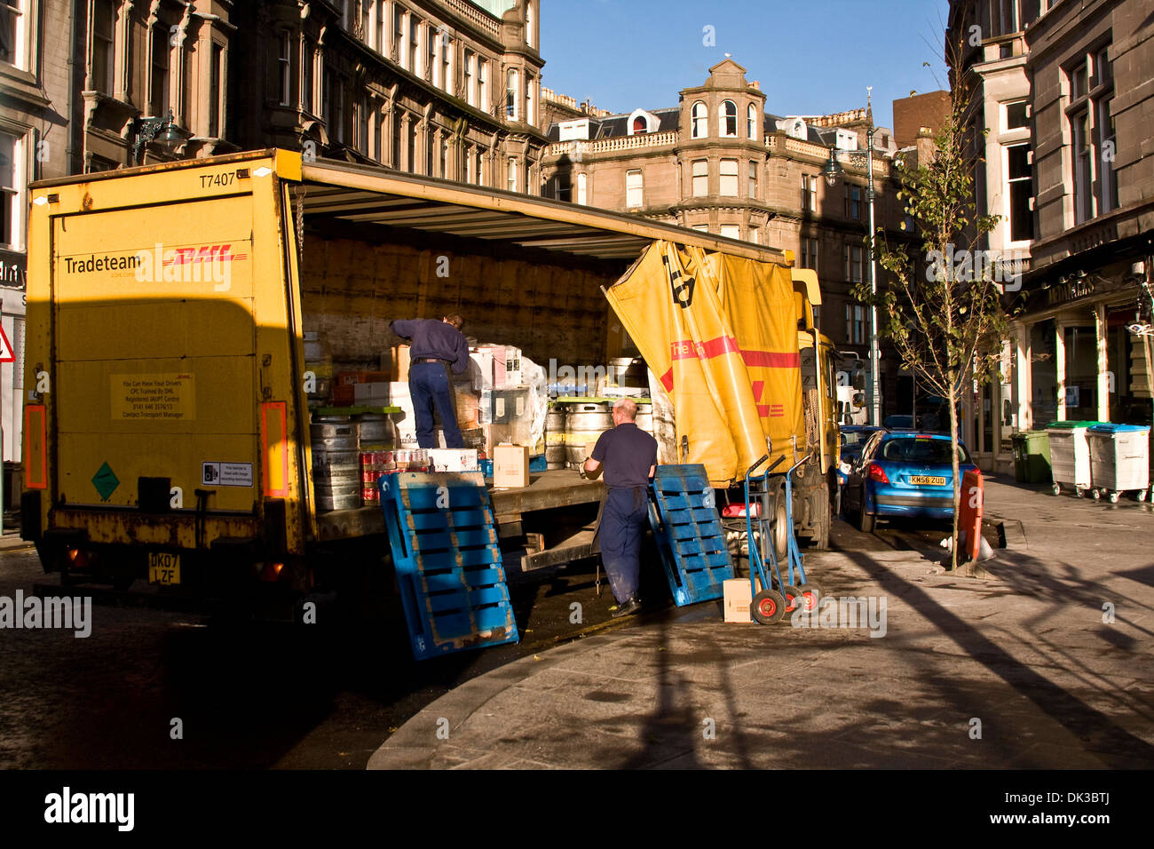 Workers unloading goods from a DHL transporter parked outside the Malmaison Hotel in Dundee, UK Stock Photo