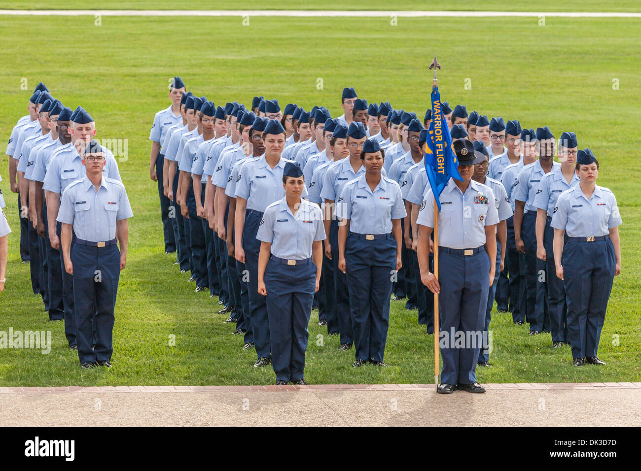Flight of airmen in dress blues stand at attention during United States Air Force basic training graduation In San Antonio, TX Stock Photo