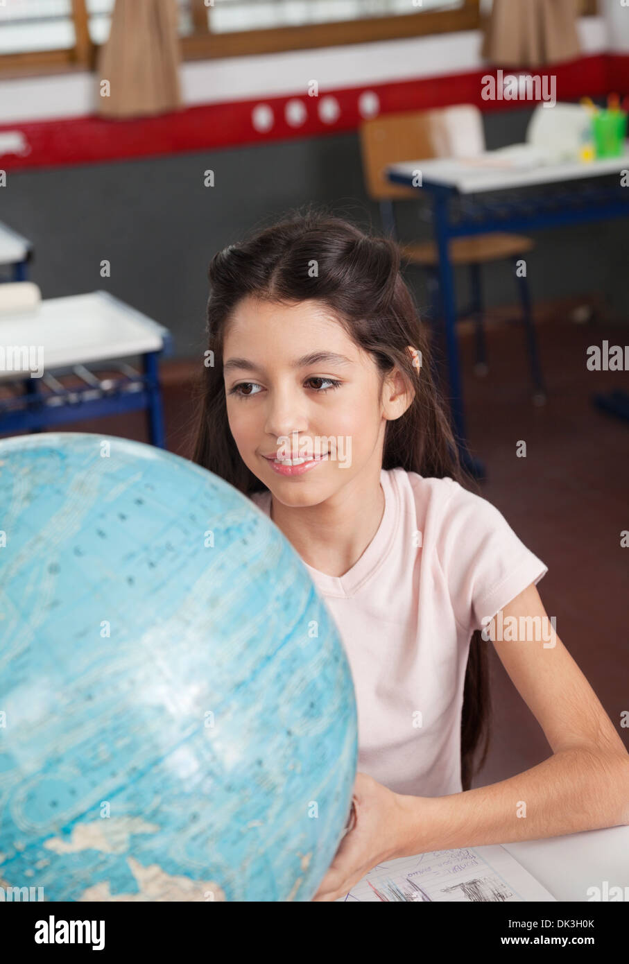 Schoolgirl Smiling While Searching Places On Globe Stock Photo - Alamy