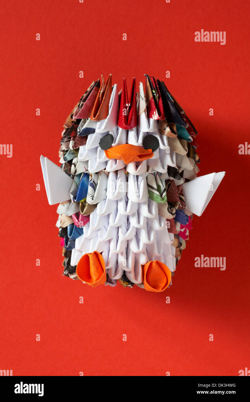 origami penguin isolated on red background Stock Photo