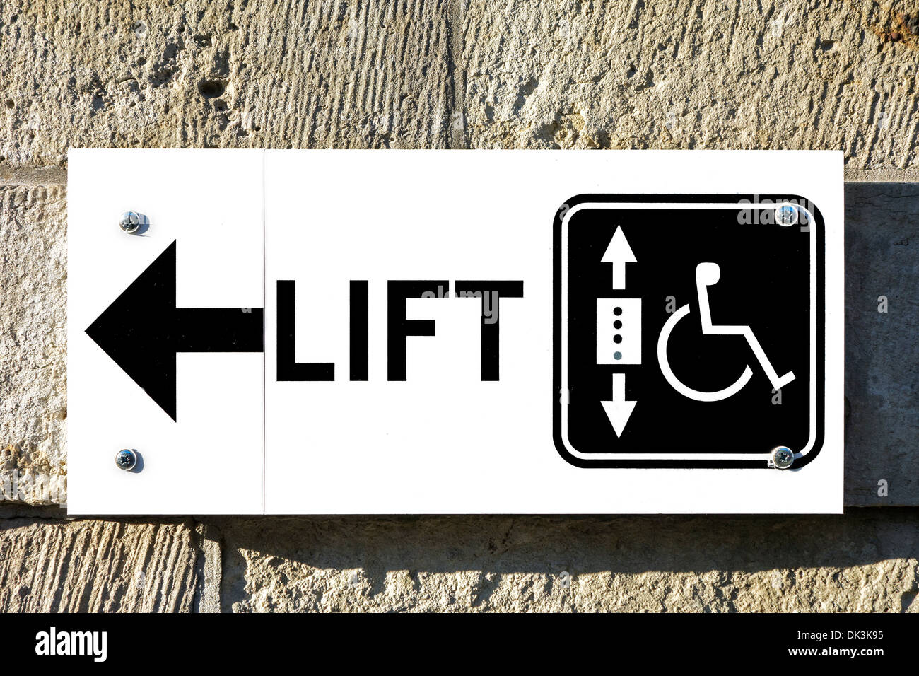 Sign with arrow showing direction to lift / elevator for wheelchair users and handicapped persons to access public building Stock Photo