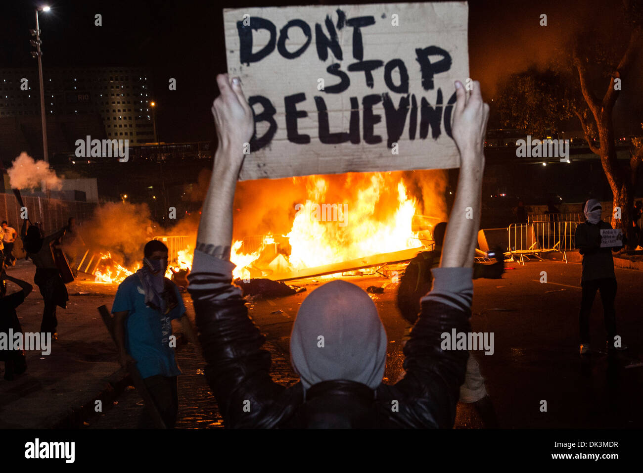 Brazil protest. Revolt, street vandalized by protesters. Banner Don´t stop believing, fire for blocking police. Stock Photo