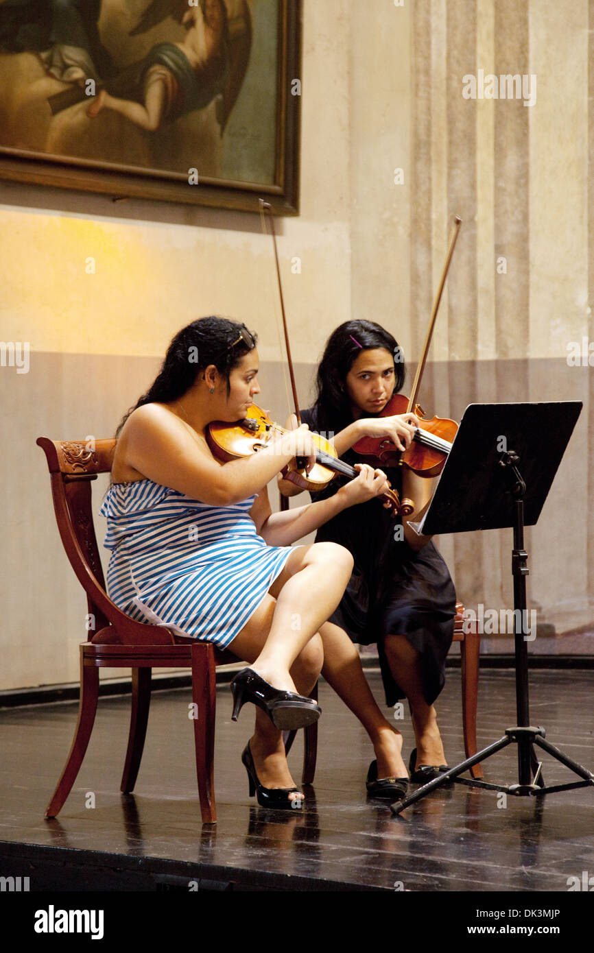 Cuba music - Two young women violinists playing the violin, Church and Convent of St Francis of Asisi, Havana Cuba, Caribbean Stock Photo