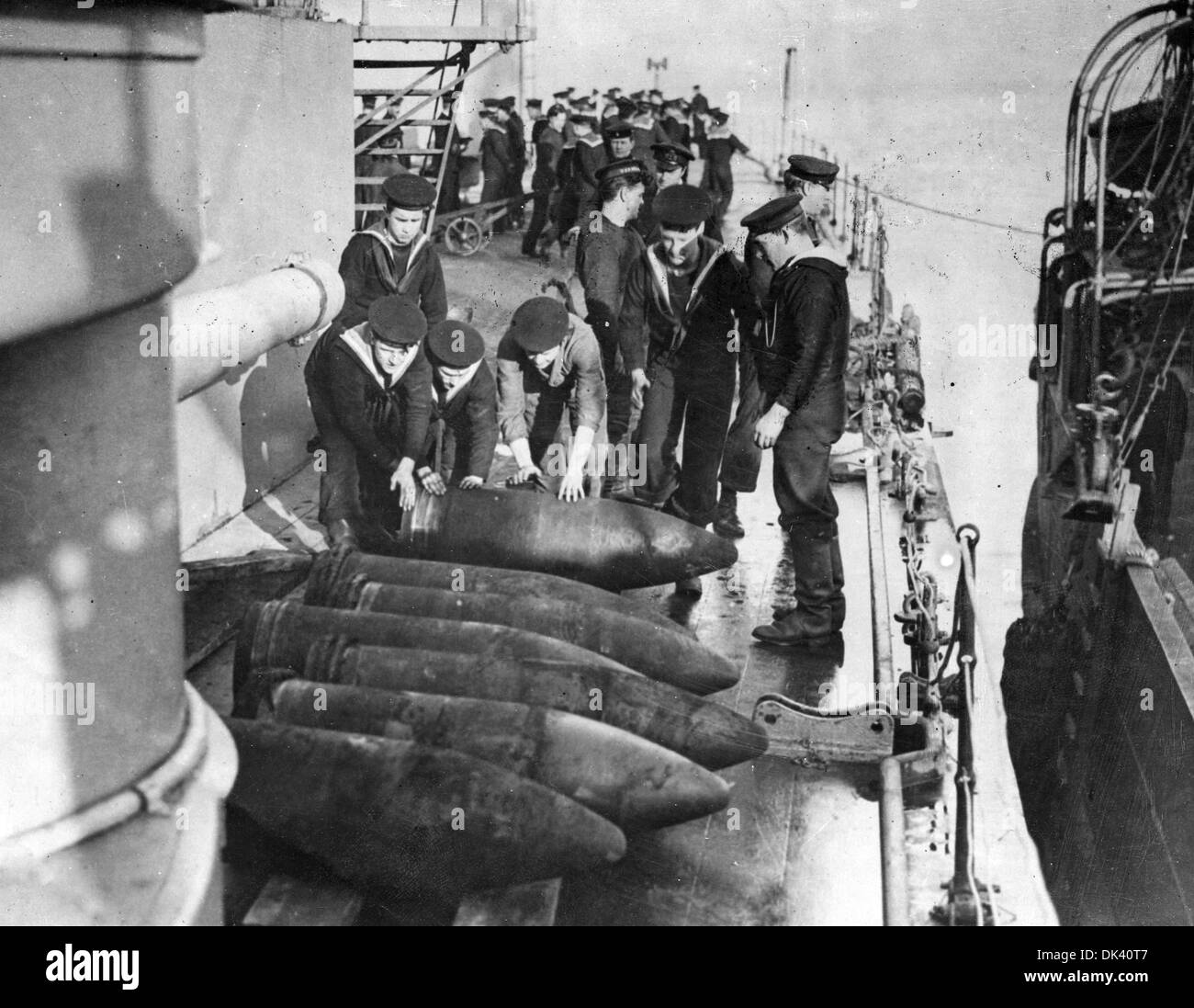 A GROUP OF SAILORS ONBOARD A WORLD WAR ONE BATTLESHIP PREPARE SHELLS FOR BATTLE Stock Photo