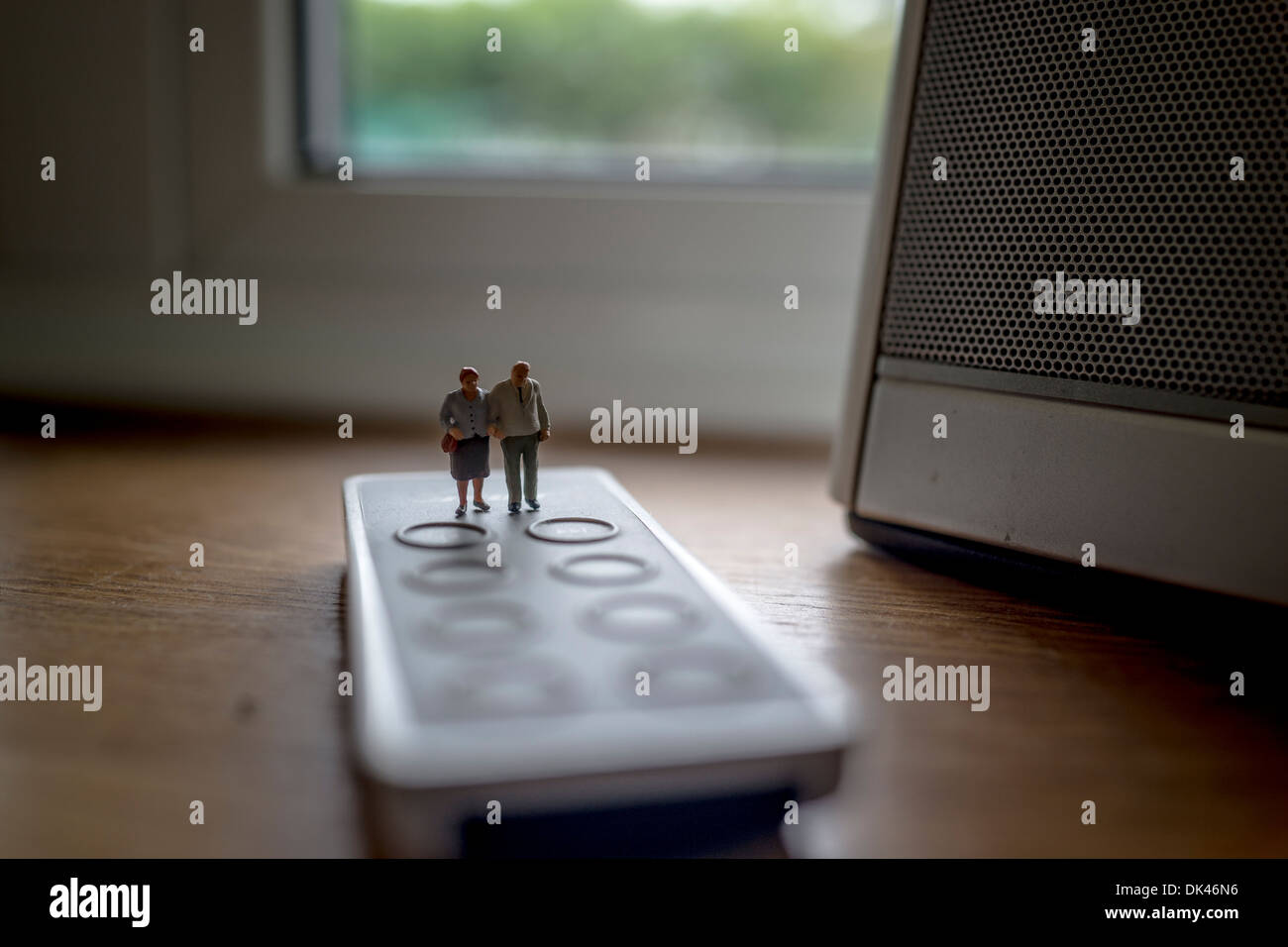 Elderly couple figurines standing on a remote control Stock Photo