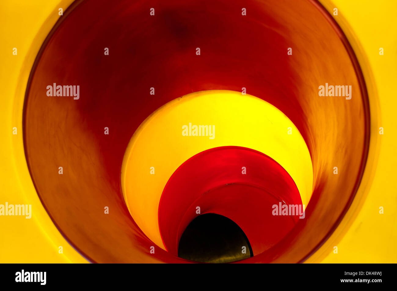 Side view of young boy on slide using inhaler in park Slide tunnel for kids in outdoor playground Stock Photo