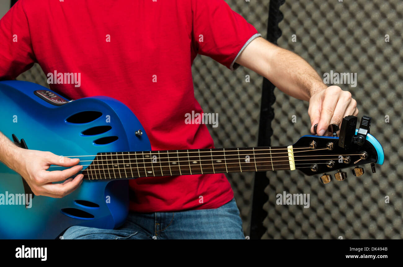 Guitarist tuning his guitar ( Series with the same model available) Stock Photo