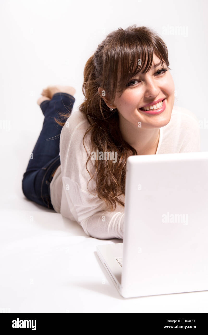 Young woman lying on floor with laptop Stock Photo - Alamy