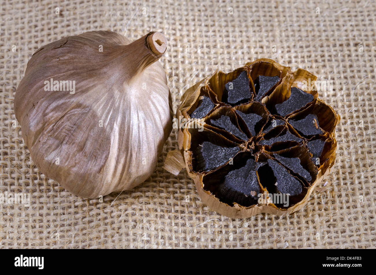Black garlic bulb with cross section showing black cloves Stock Photo