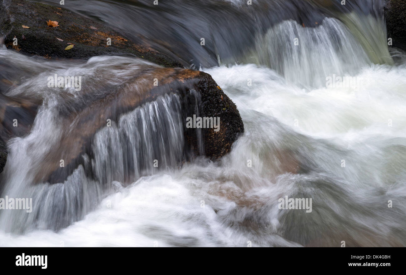 Fast flowing water cascading over rocks Stock Photo