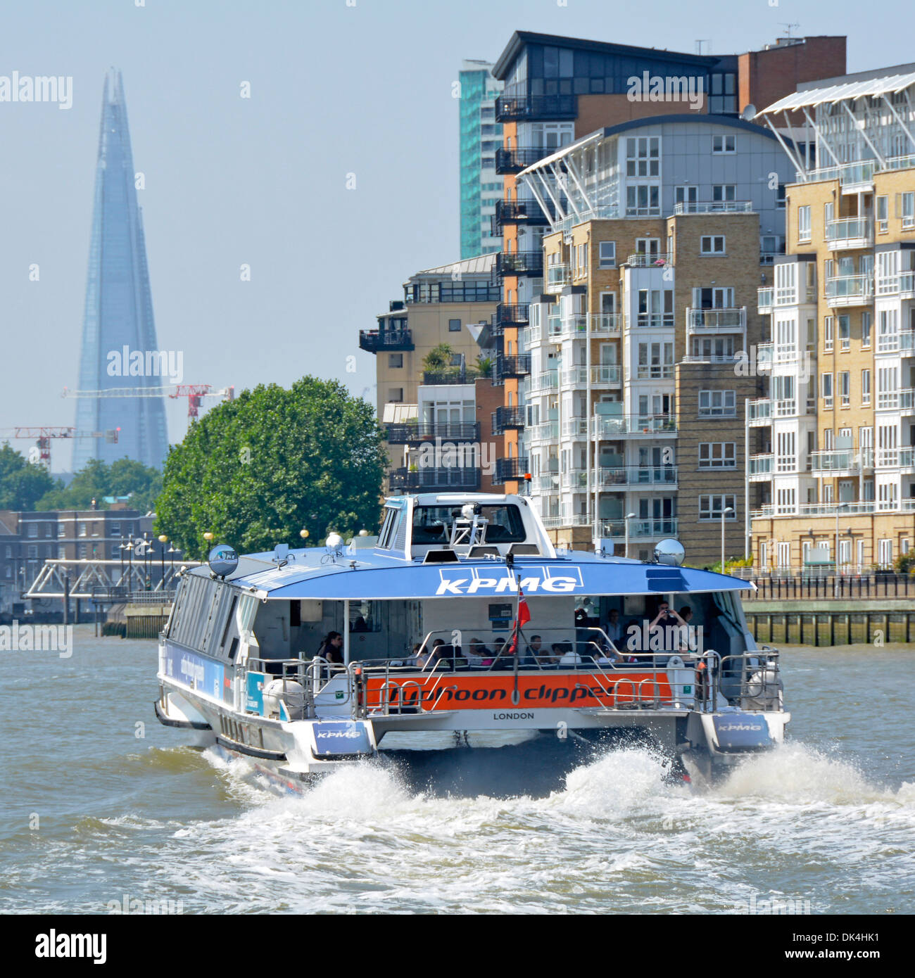Stern view of catamaran design of Thames clipper river water-bus service with London Shard building beyond Stock Photo