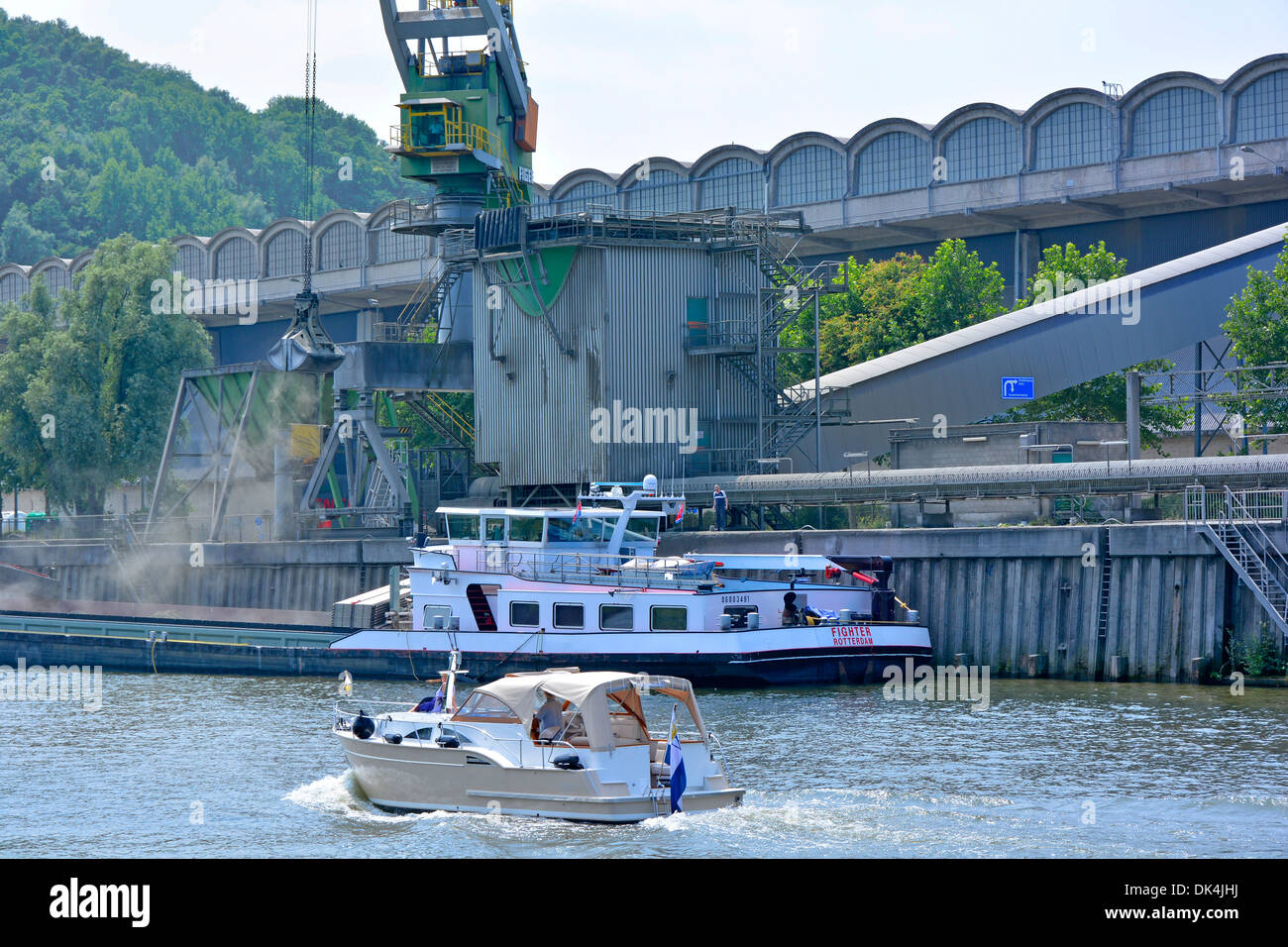 Leisure motor boat (name removed) on River Meuse passing Dutch Enci cement works Netherlands EU Stock Photo