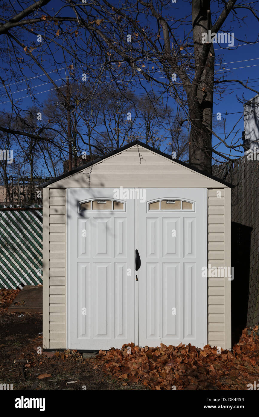 Storage shed at the backyard with leaves on the ground Stock Photo