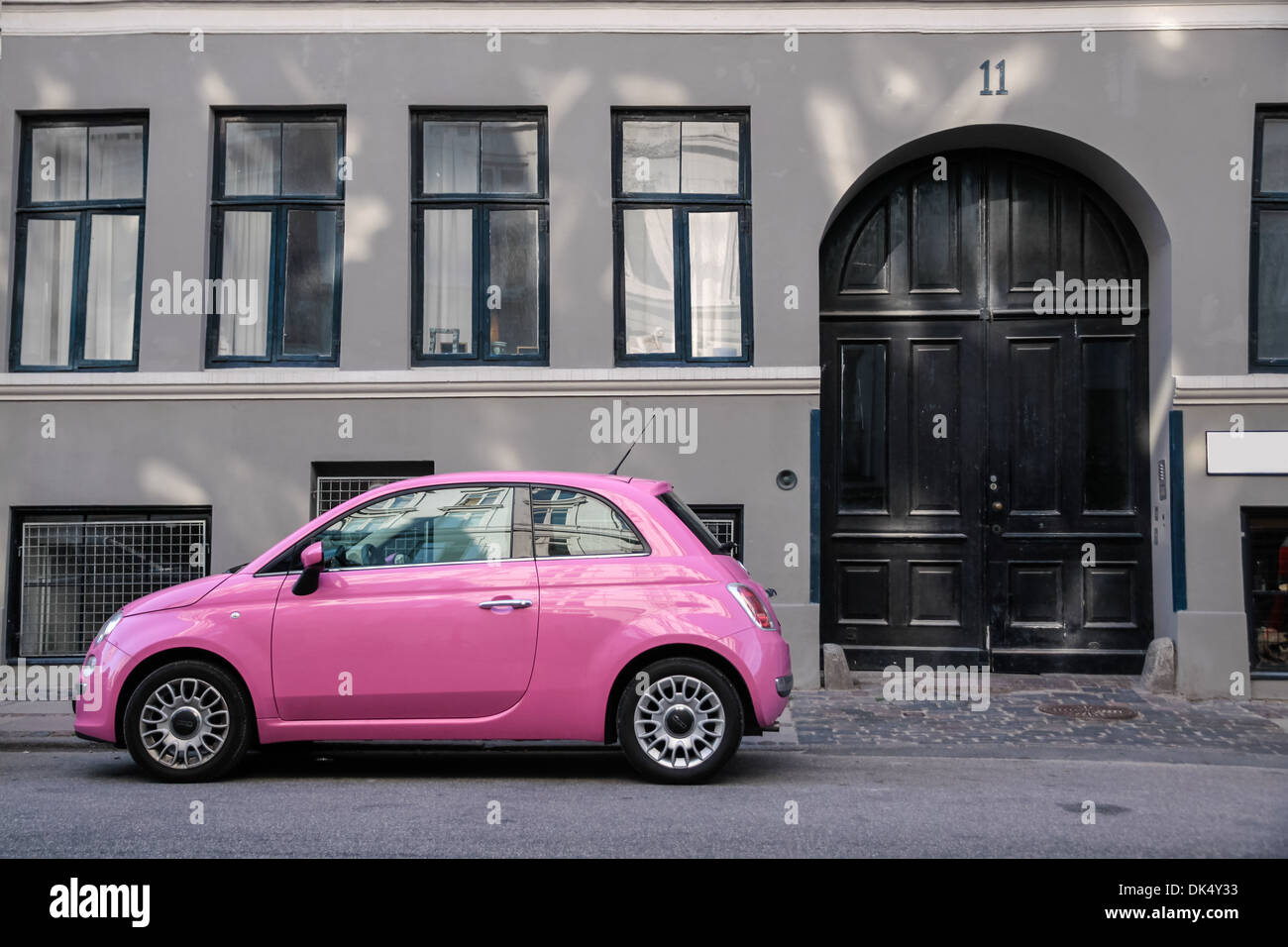 Funny pink car in front of a gray house in Copenhagen, Denmark Stock Photo