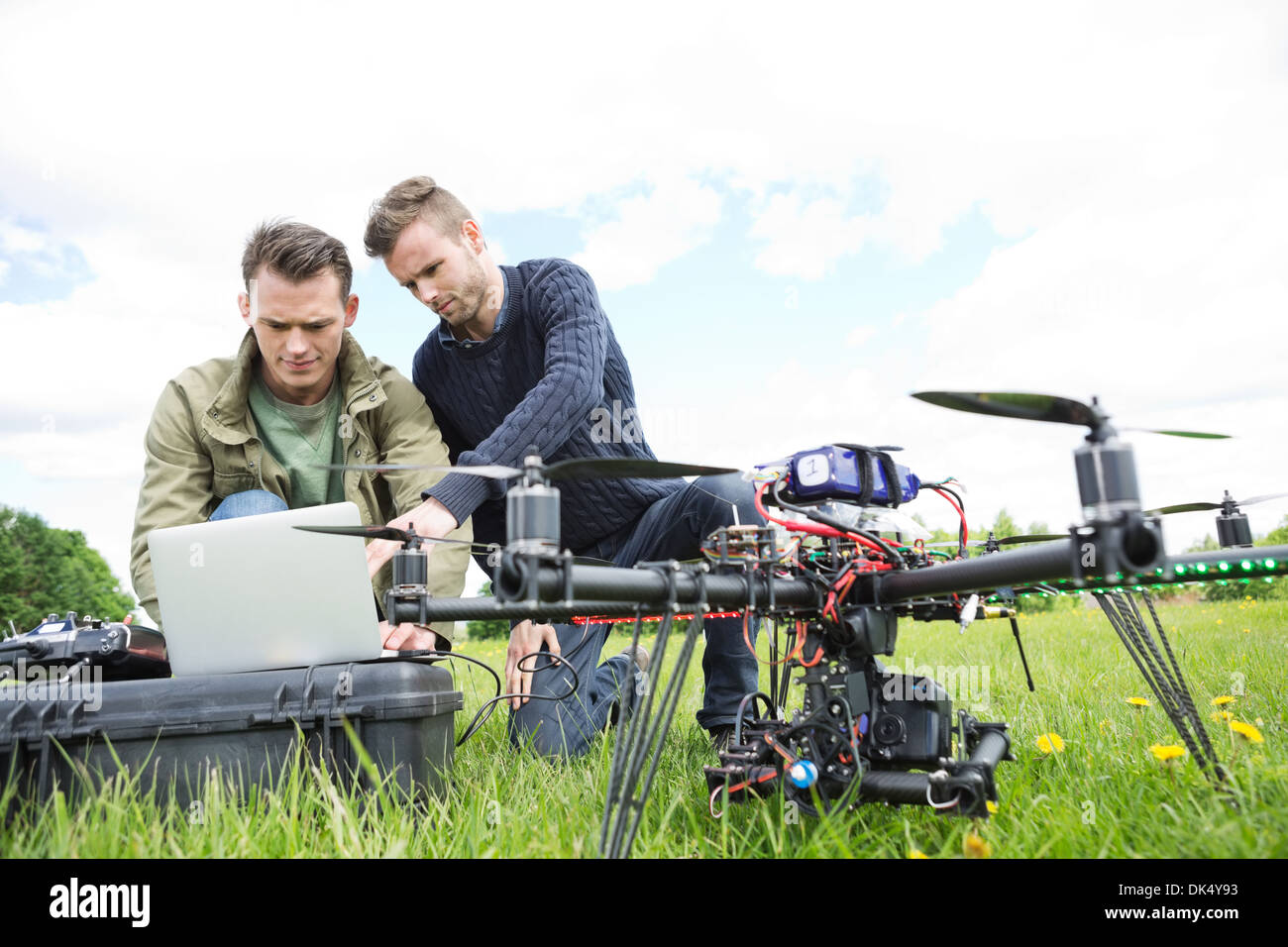 Engineers Using Laptop By UAV Octocopter Stock Photo