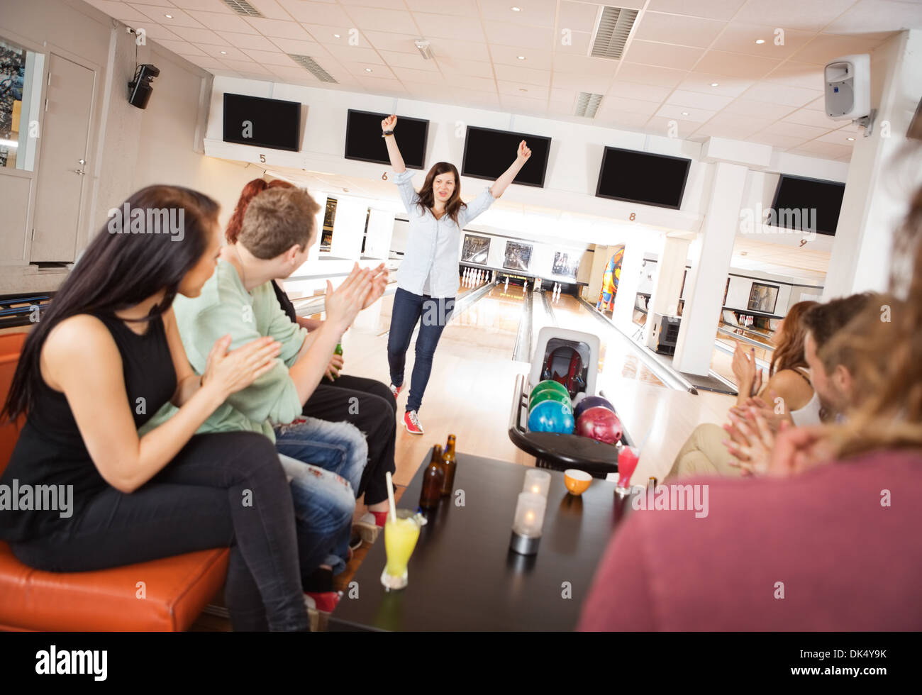 Excited Woman With Friends Applauding Stock Photo