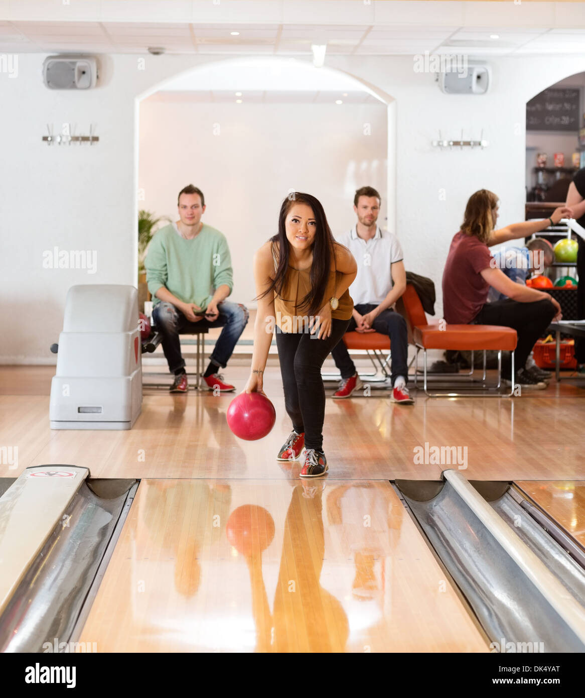 Woman Throwing Bowling Ball in Club Stock Photo