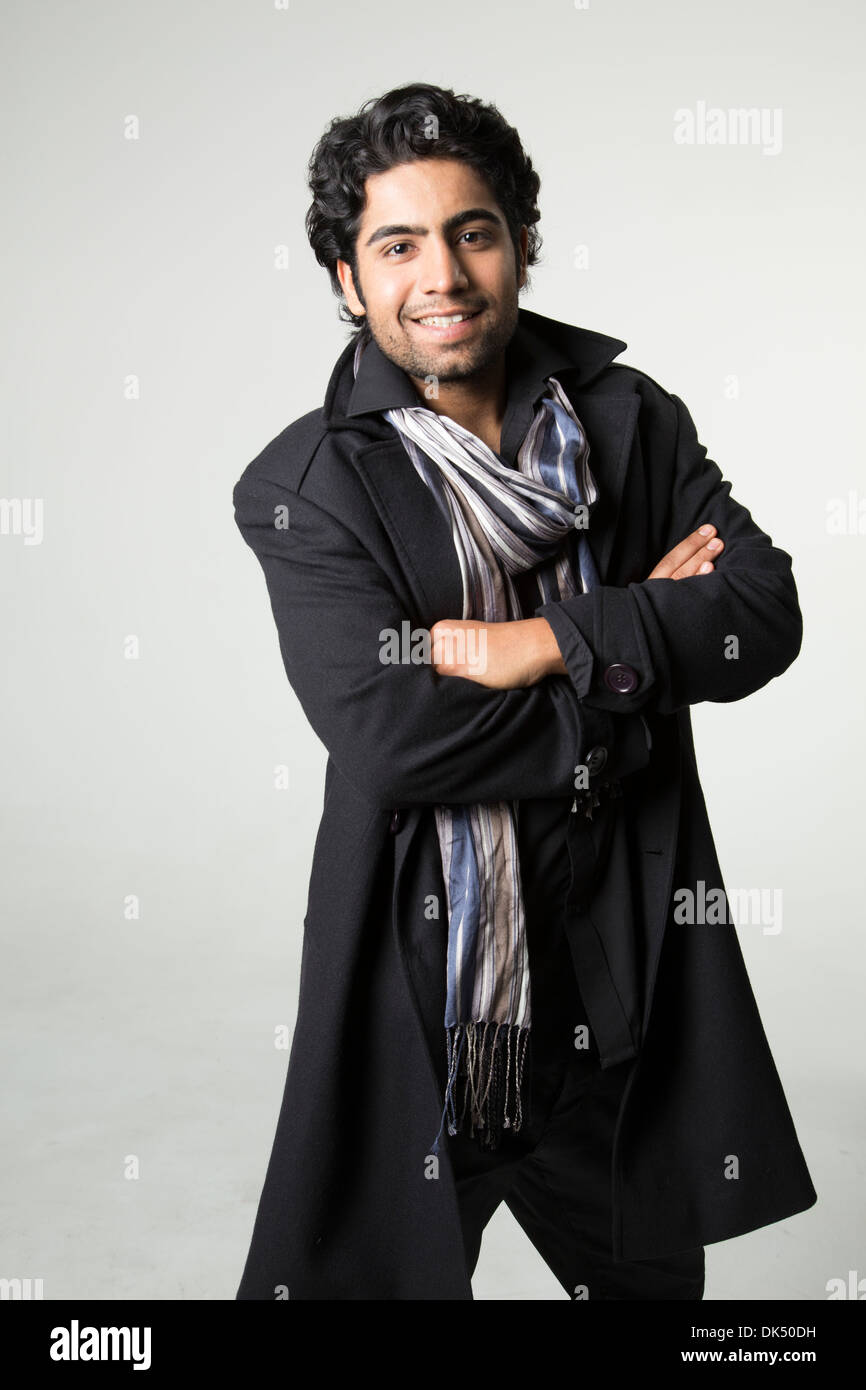 Smiling young Indian man with his arms folded Stock Photo