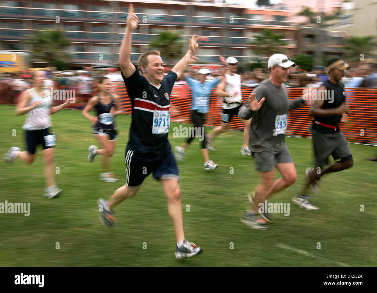 Apr. 17, 2011 - San Diego, California, USA - April 17, 2011- SAN DIEGO, CA-Mark (cq) Stickel of San Diego, foreground, raises his arms as he and others get ready to cross the finish line of the La Jolla Half Marathon in Ellen Browning Scripps Park at La Jolla Cove. (Howard Lipin/San Diego Union-Tribune) Mandatory Photo Credit: HOWARD LIPIN/ San Diego Union-Tribune/ZUMA PRESS, San D Stock Photo