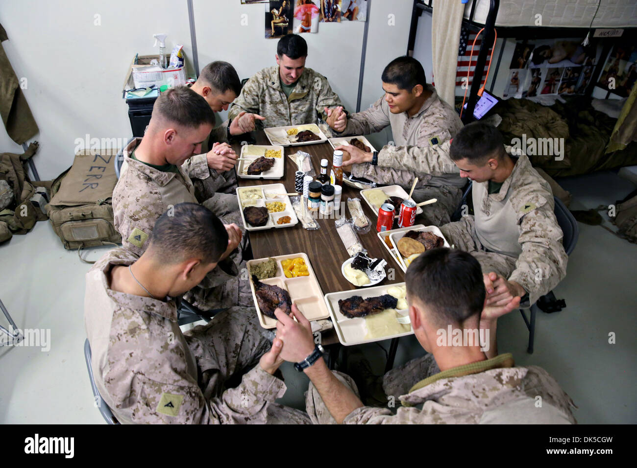 US Marines serving with 3rd Battalion, 7th Marine Regiment's Security Force Advisor Team pray before they enjoy their Thanksgiving dinner November 28, 2013 in Delaram, Afghanistan. Stock Photo