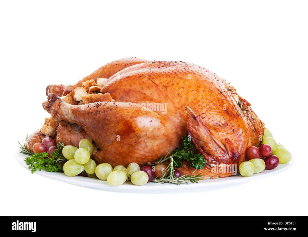 A large a stuffed turkey on a platter garnished with grapes. Stock Photo