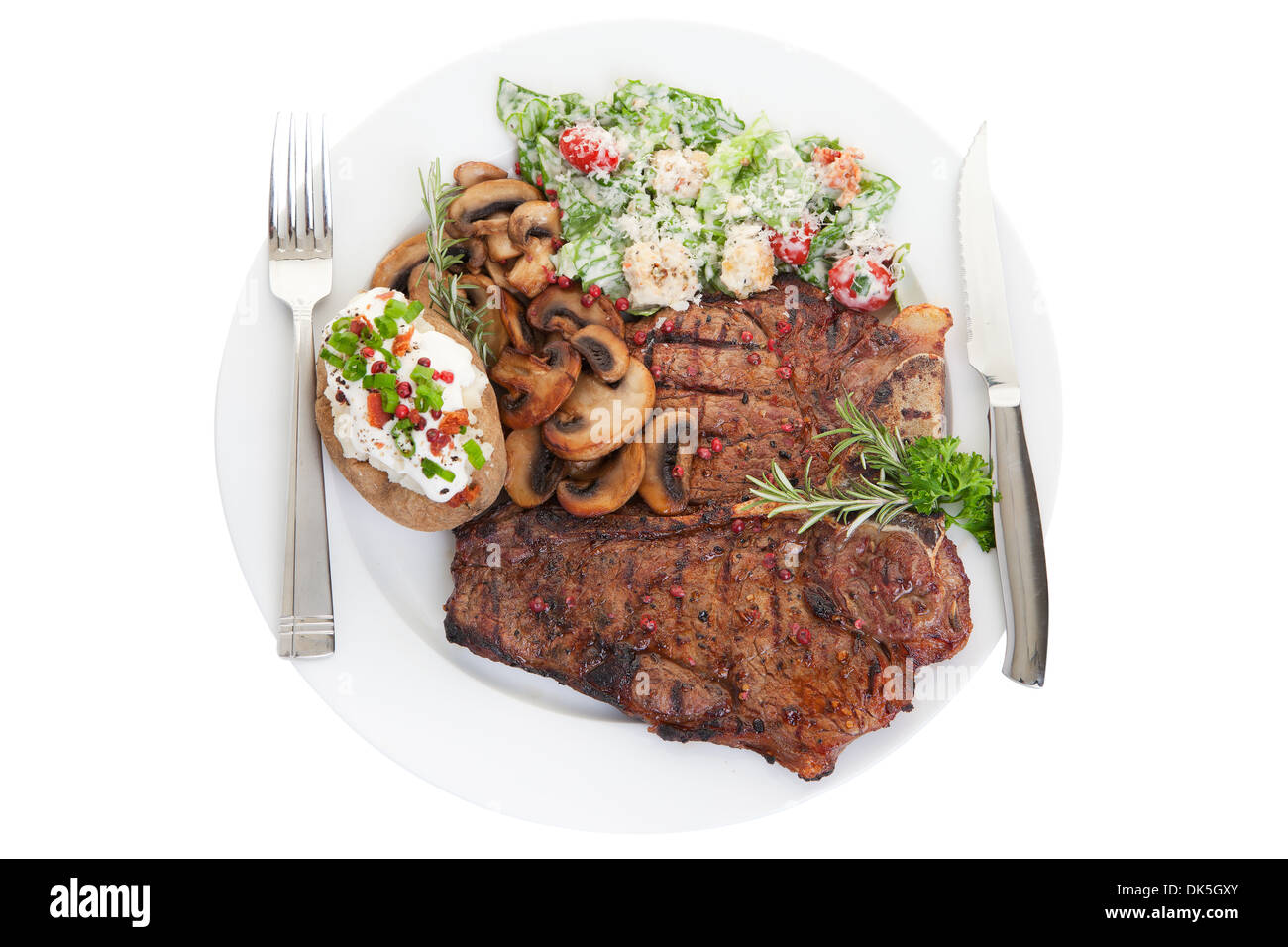 Grilled beef t bone steak dinner with Caesar salad, mushrooms and rosemary Stock Photo
