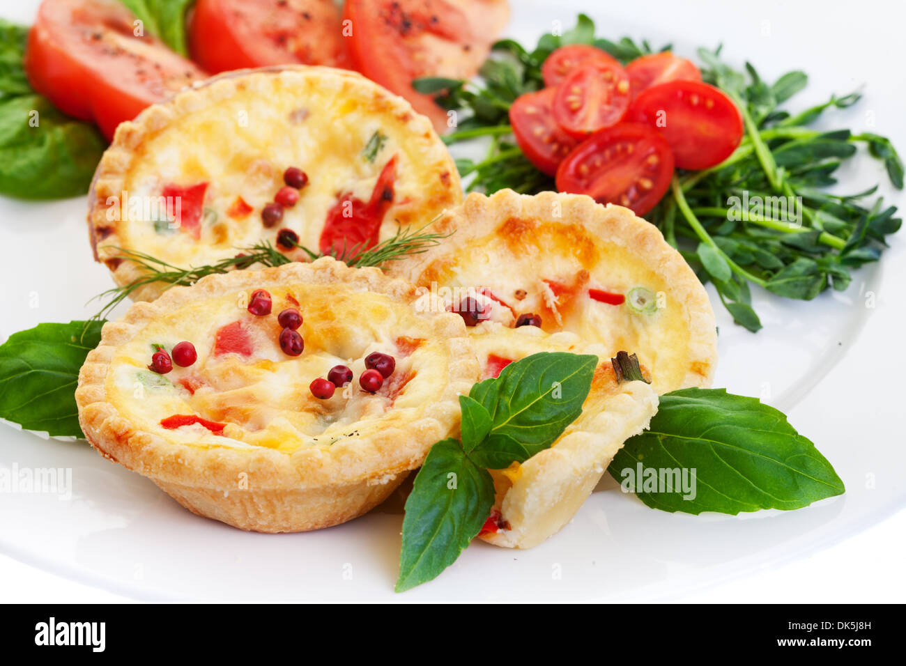 Mini quiche filled with vegetables with salad.Focus on the front pie. Stock Photo