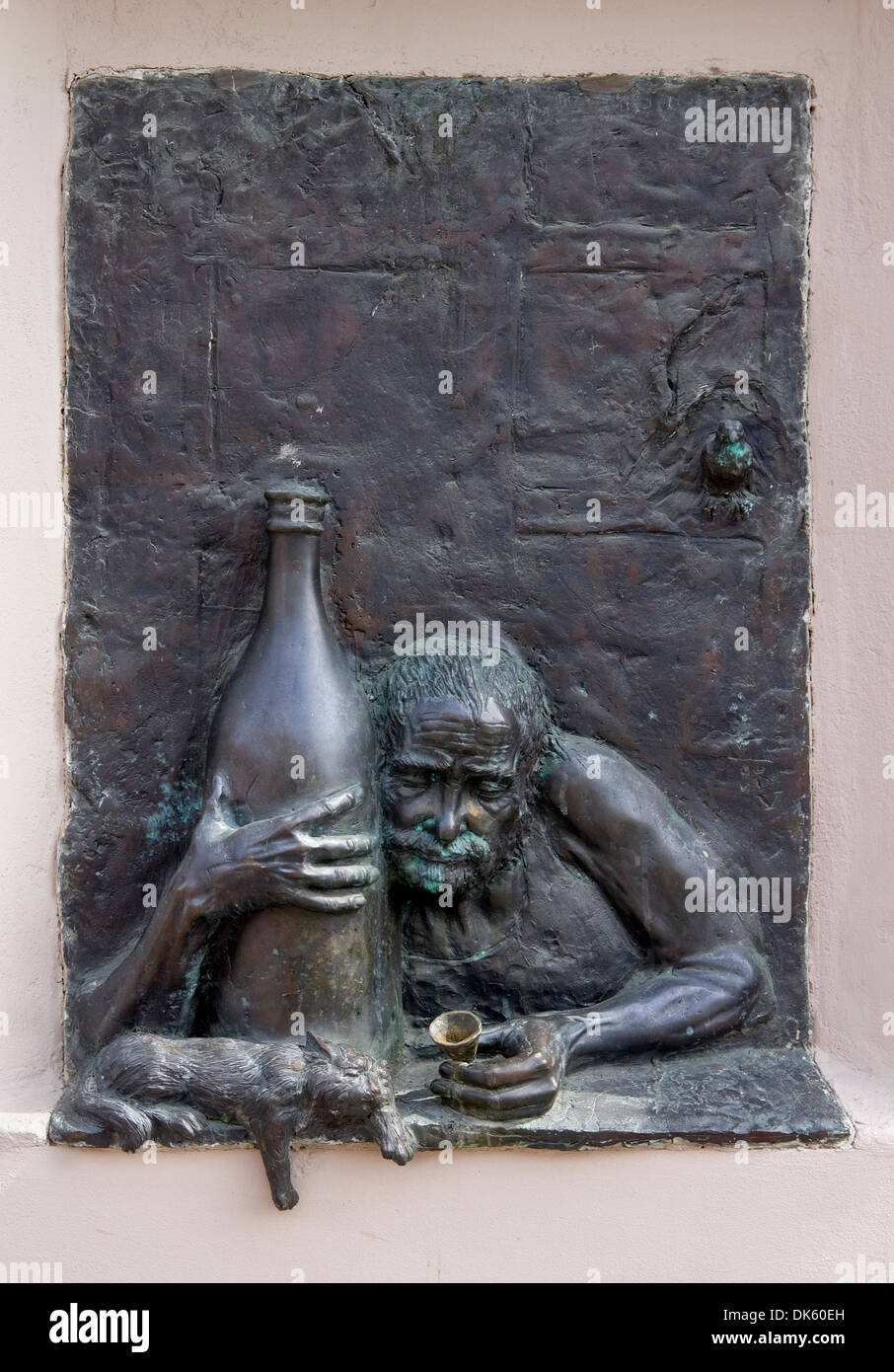 Old drunkard alcoholic and a cat bronze bas-relief Stock Photo