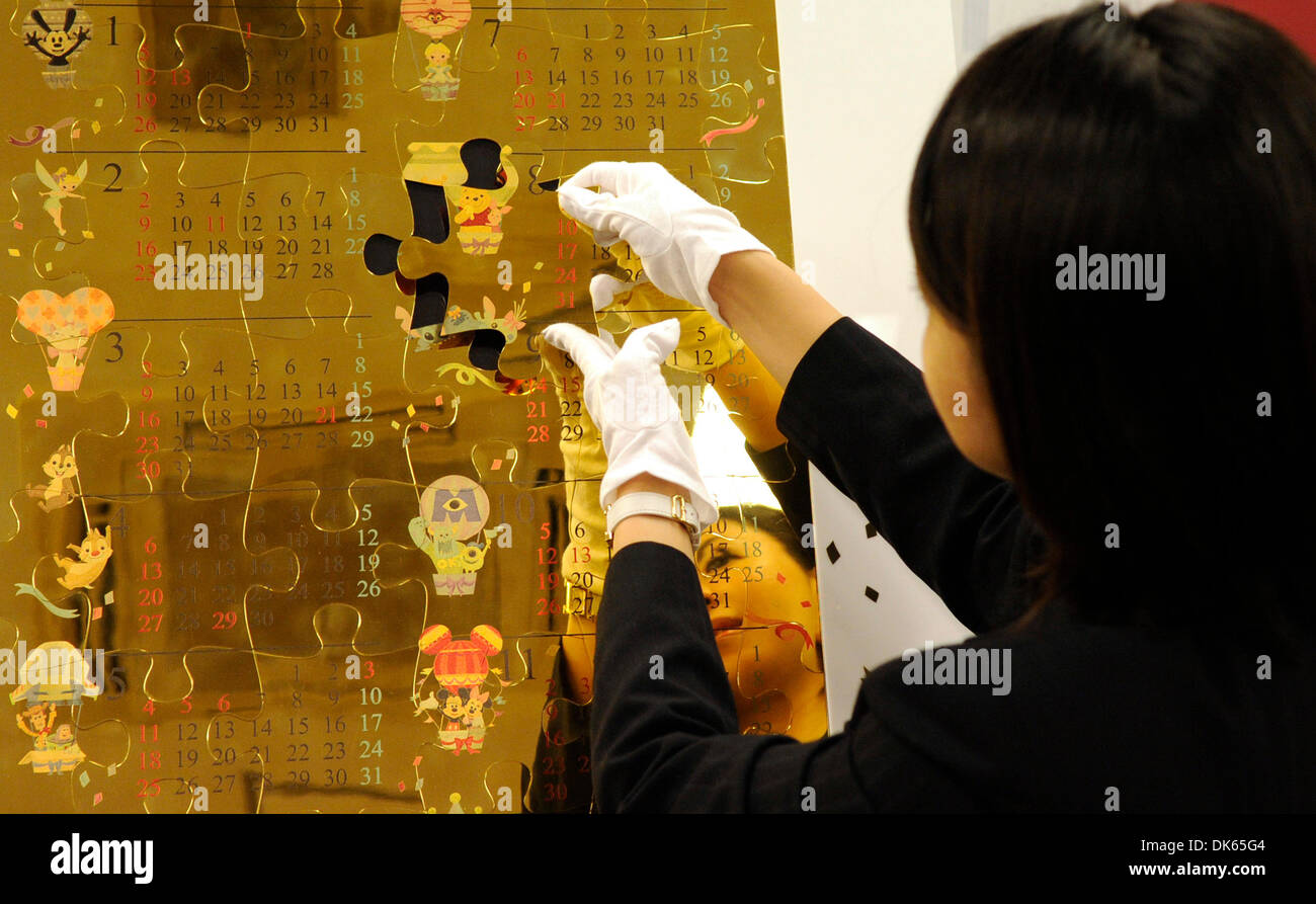 (131203) -- TOKYO, Dec. 3, 2013 (Xinhua) -- A Japan's jewelry shop Ginza Tanaka's employee puts togeter puzzles of 'Disney Pure Gold Big Calender' in Tokyo, Japan, Dec. 3, 2013. 'Disney Pure Gold Big Calender' is made of 54 puzzle pieces (10 kilogram pure gold). Ginza Tanaka sells at a price of 100,000,000 JPY(around 1,013,880 US dollars). (Xinhua) Stock Photo