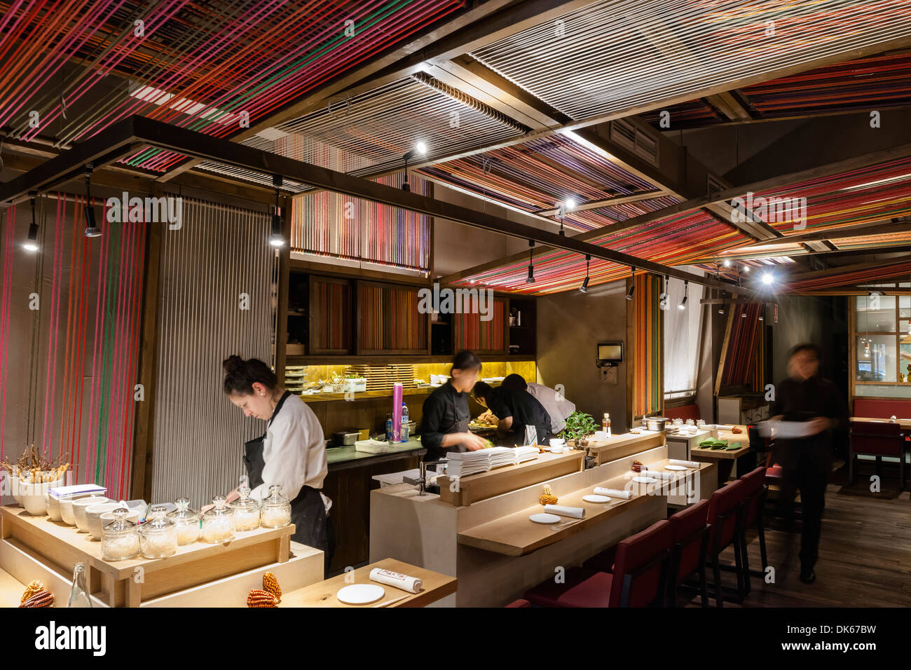 Patka Restaurant, Barcelona, Spain. Architect: El Equipo Creativo, 2013. View along bar counter with chef at work. Stock Photo