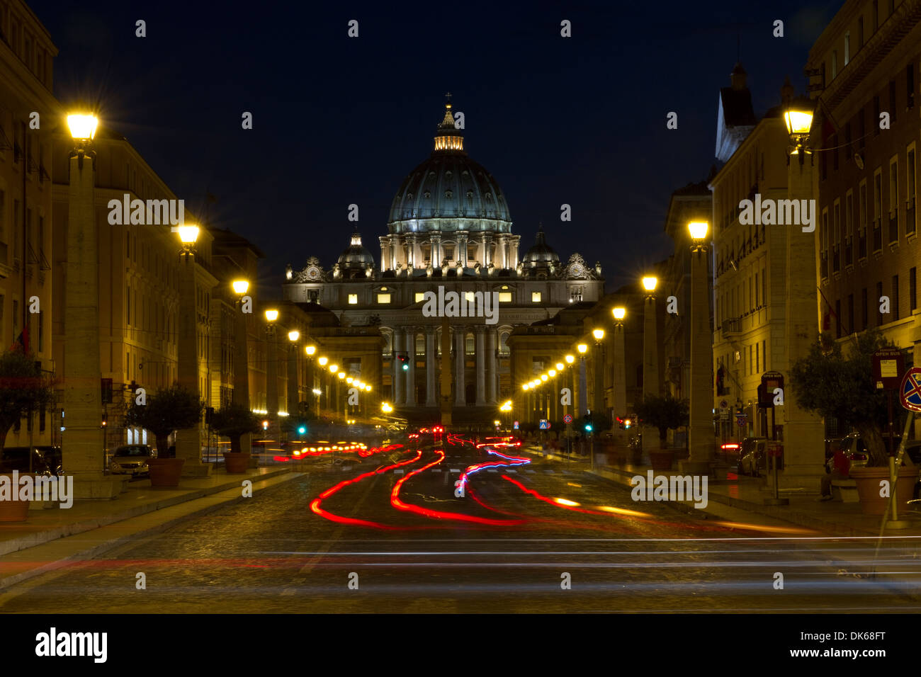 Car tail lights heading up Via della Conciliazione in Rome, Italy, with St. Peter's Basilica, Vatican City, in the background. Stock Photo