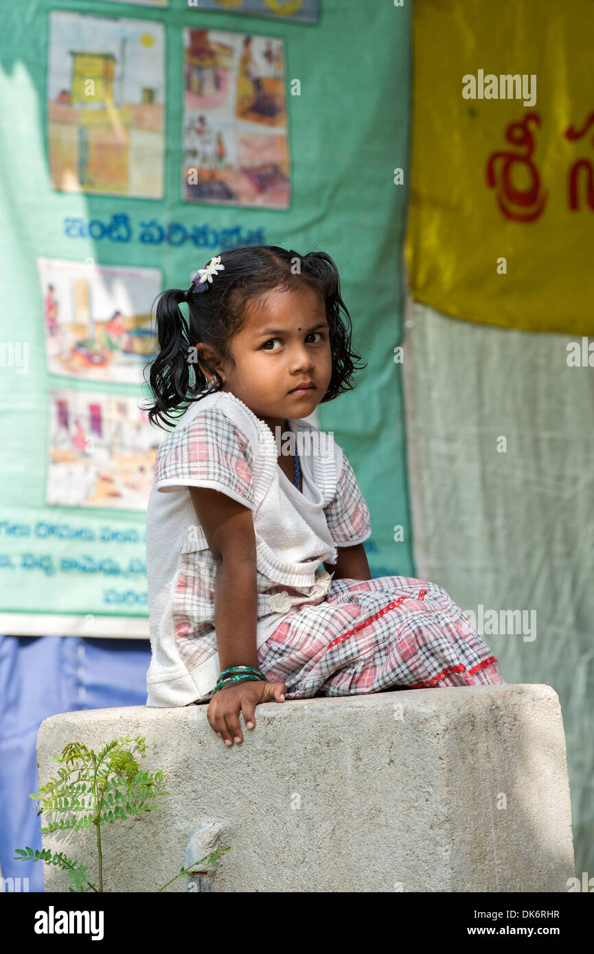 Young Indian girl sitting on a concrete post in a rural Indian village. Andhra Pradesh, India Stock Photo
