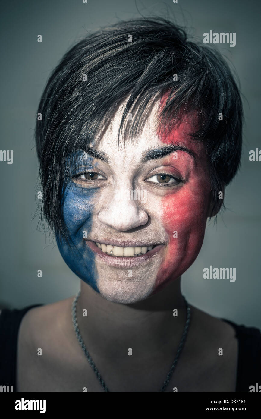Portrait of happy woman with flag of France painted on face. Stock Photo