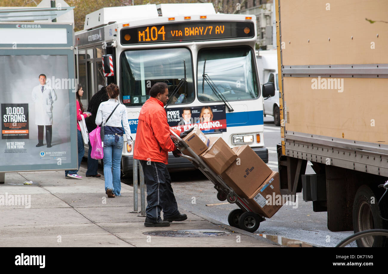 Delivery man with boxes on a trolley in Manhattan New York USA Stock