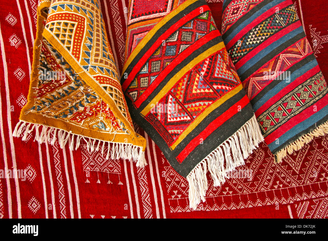 Pile of North African rugs in red, orange & brown shades, Tunisia. Stock Photo
