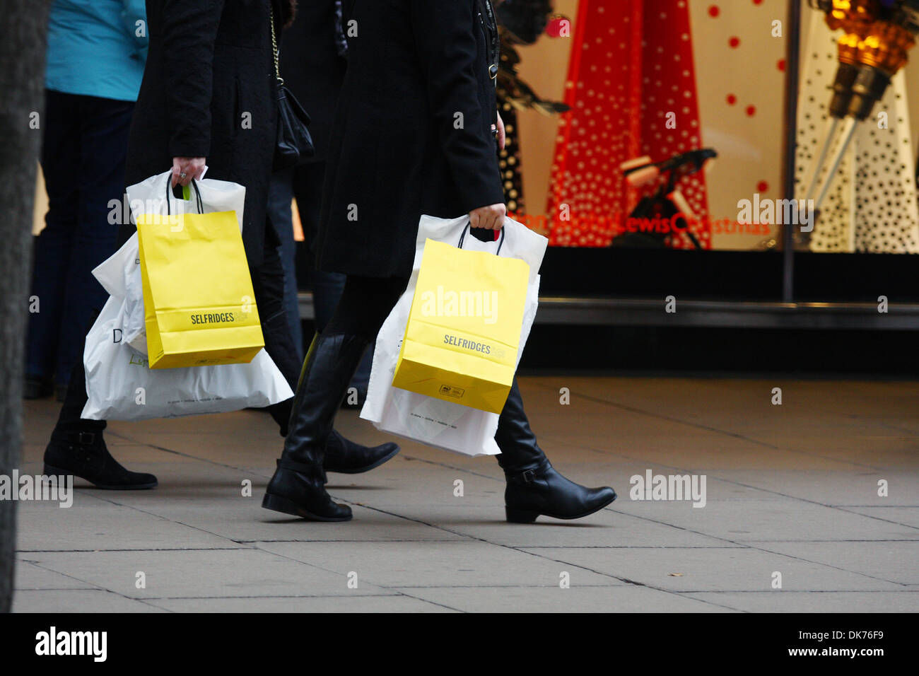 Part of two people carrying Selfridges and other shopping bags along Oxford Street in London England Stock Photo