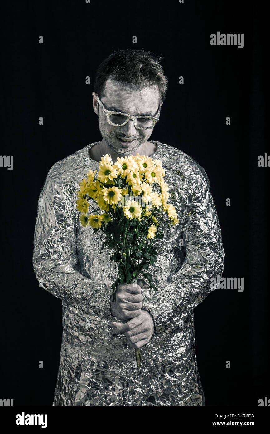 Portrait of satisfied spaceman holding flowers. Stock Photo