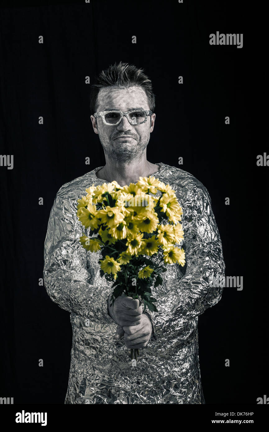 Portrait of happy spaceman holding flowers. Stock Photo