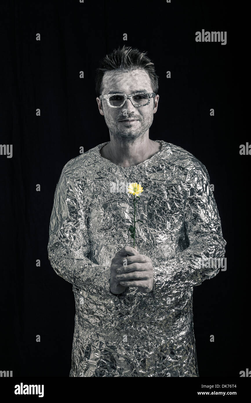 Portrait of happy spaceman holding flower. Stock Photo