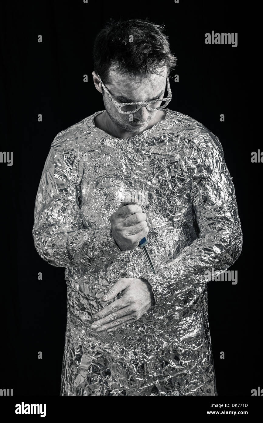 Portrait of cyborg man fixing himself with screwdriver. Stock Photo