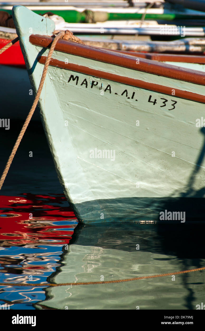 Fishing boat hull reflected in the water of Kioni harbour Stock Photo