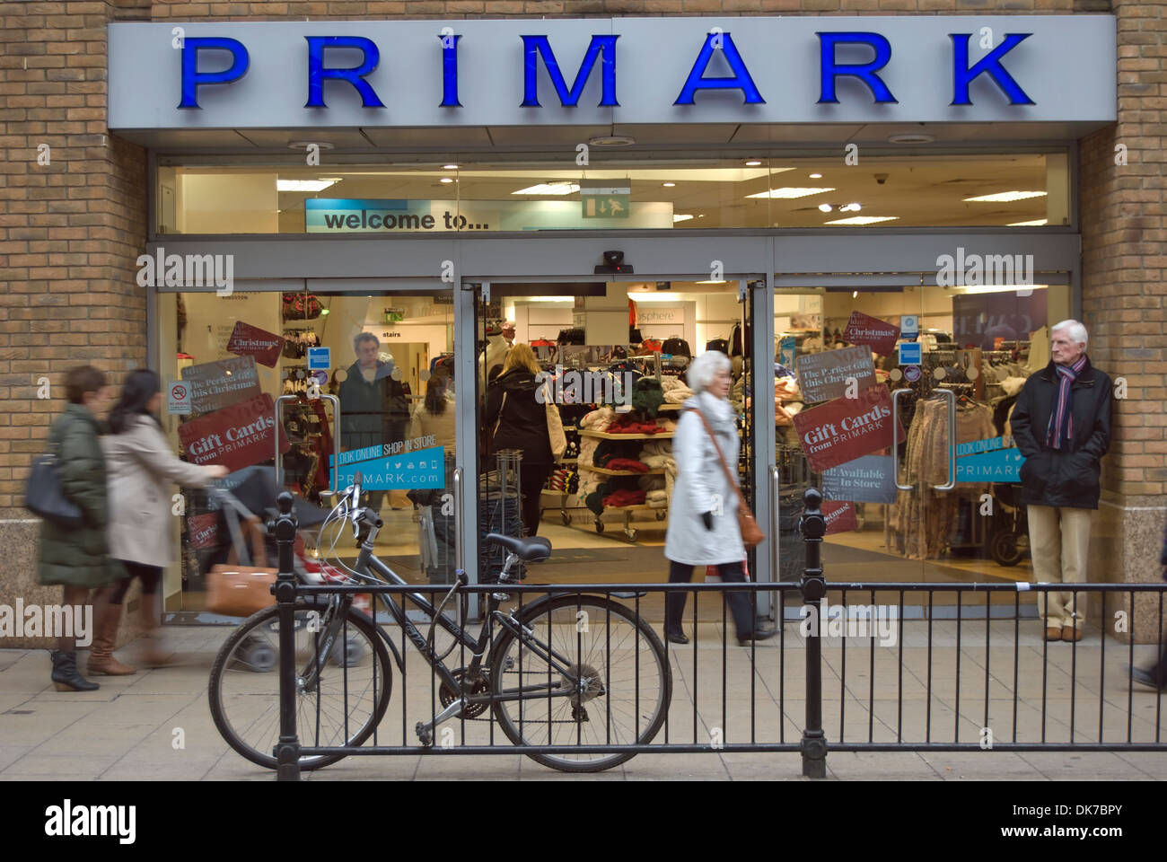 shoppers milling in and around the entrance to a branch of clothing ...